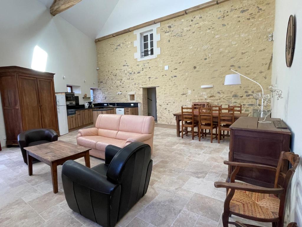 ein Wohnzimmer mit einem Sofa und einem Tisch in der Unterkunft La Maison des Poètes 6 personnes à Treigny Perreuse in Perreuse
