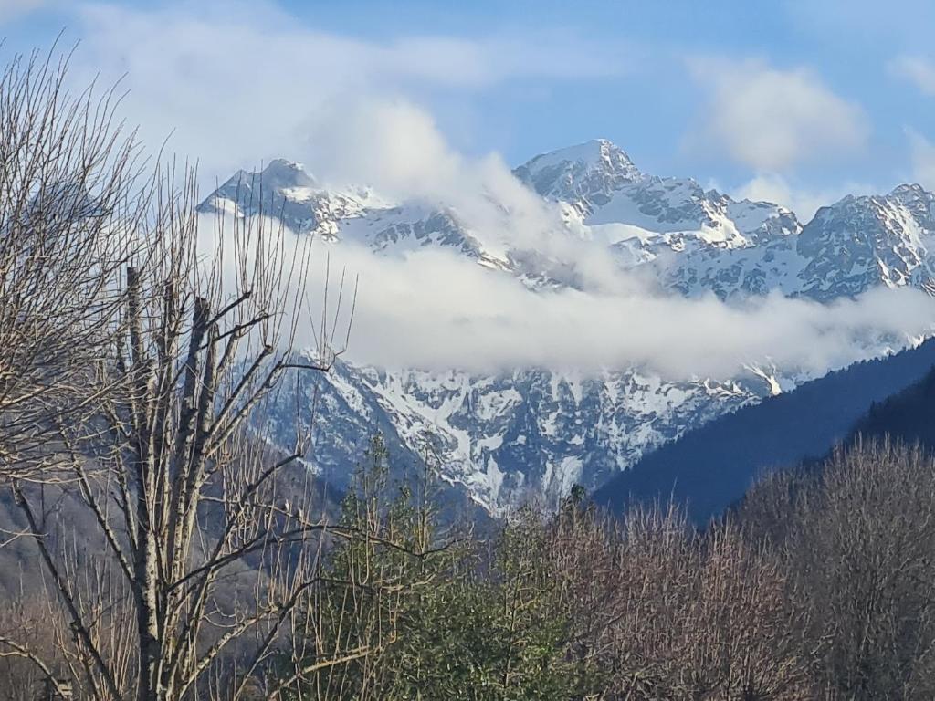 uma montanha coberta de neve com nuvens à sua frente em Gite de l'Ours em Saint-Mamet
