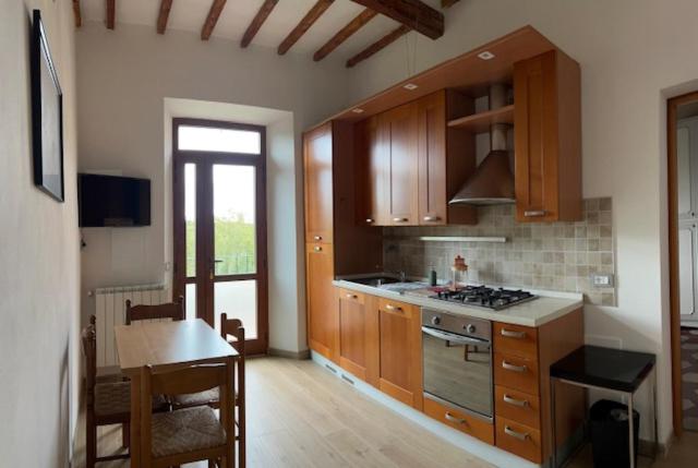una cucina con armadi in legno e piano cottura. di Siena Apartment 2 Parcheggio privato e giardino a Siena
