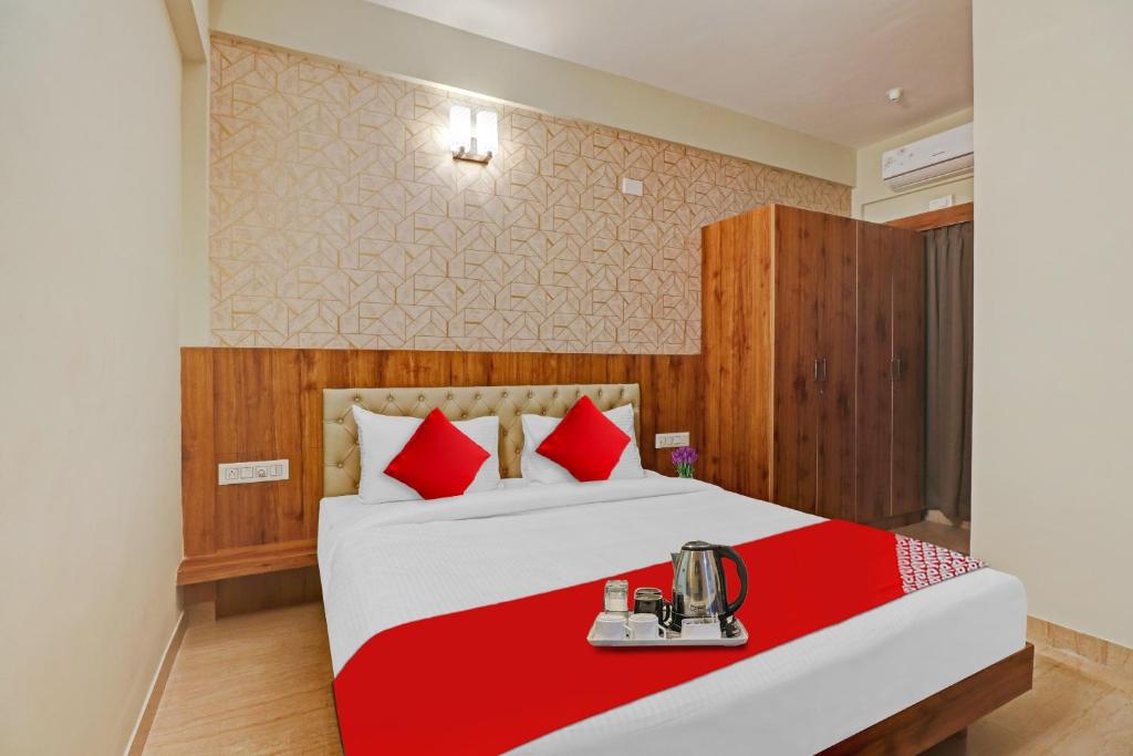 a bedroom with a large bed with red pillows at Global Stay Near Kengeri Bus Terminal Metro Station in Bangalore