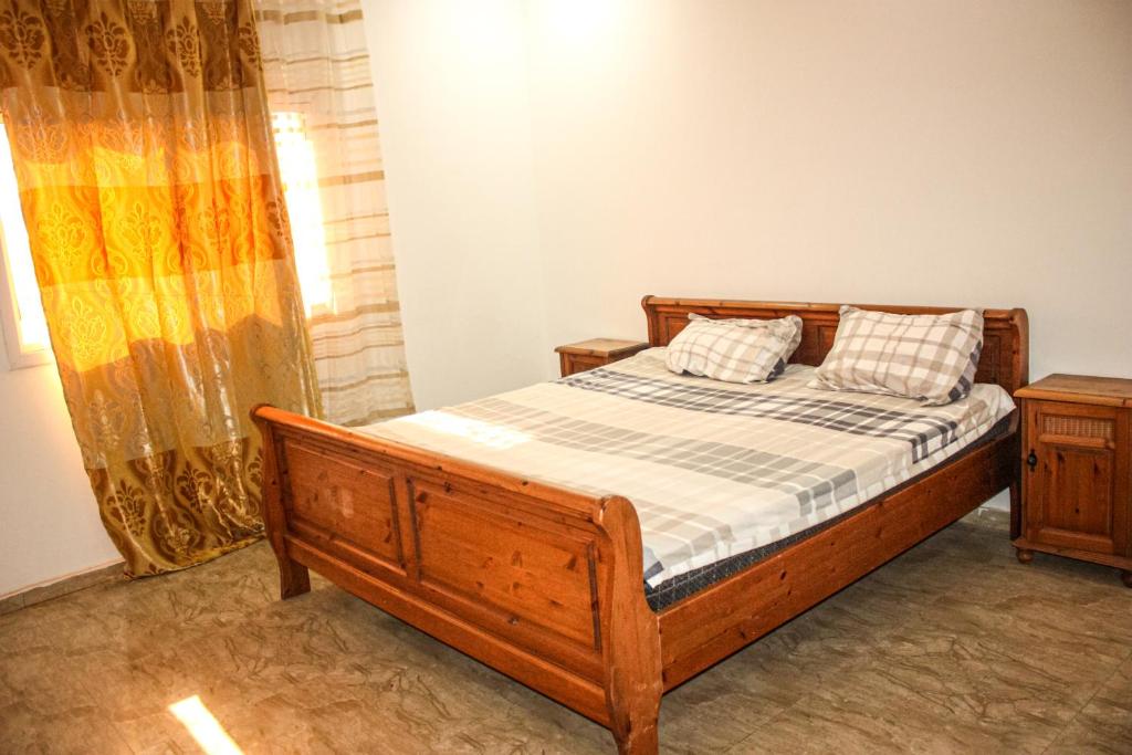 1 dormitorio con 1 cama y 2 mesitas de noche en jollof creek, en Banjul