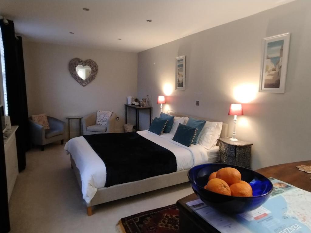 a bedroom with a bed and a bowl of fruit on a table at 1 Courtyard Mews in Penzance