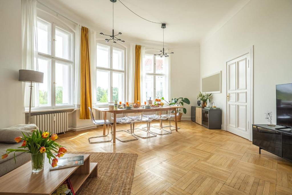 a living room with a table and chairs in it at K132 bis 10 Personen 155 sqm 3 Bedrooms 2 Bathrooms 2OG Aufzug 2 Balkone Boxspringbetten in Berlin
