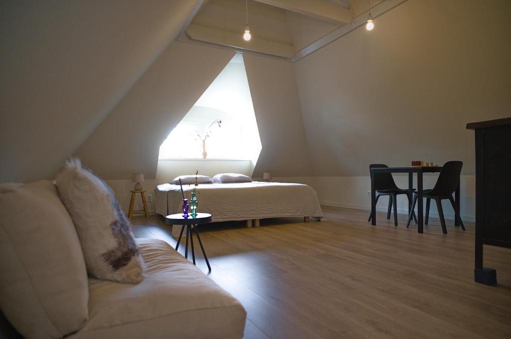 uma sala de estar com um sofá e uma cama em WetterLoft - Luxe appartement met aanlegsteiger en terras em Terherne