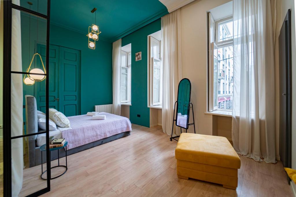 1 dormitorio con paredes verdes, 1 cama y ventanas en Elizabet house en Tiflis