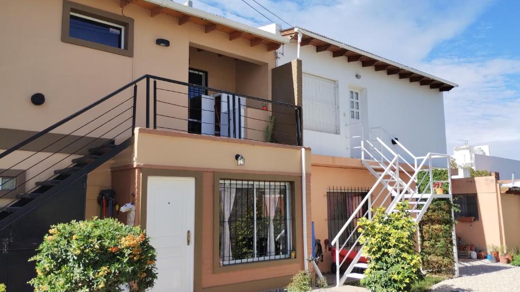 een huis met een balkon en een trap bij APA Jazmín Sur 1 y 2 - tranquilo complejo residencial in Puerto Madryn