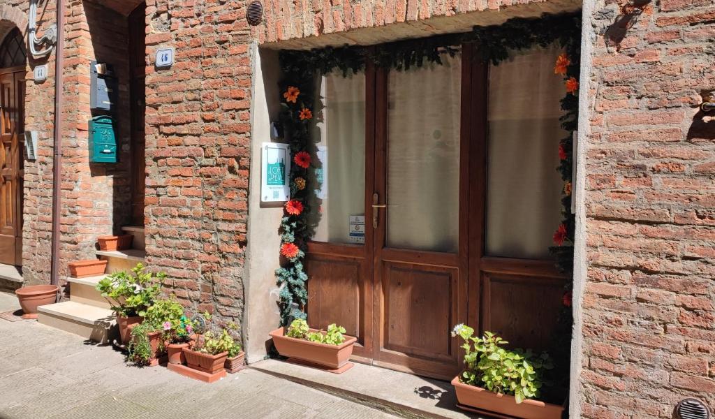 a brick building with a wooden door with flowers on it at Il Loft di Pieve in Città della Pieve