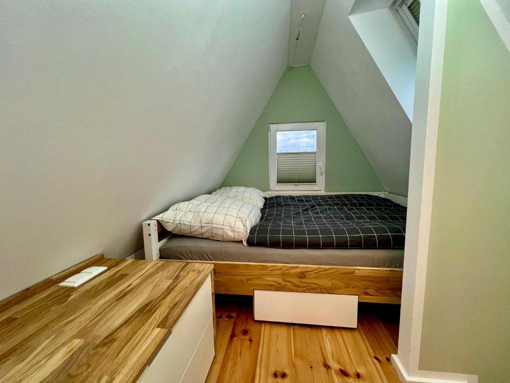 a small bedroom with a bed in the attic at Finnhütten am Storkower See - Urlaub in der Natur in Storkow