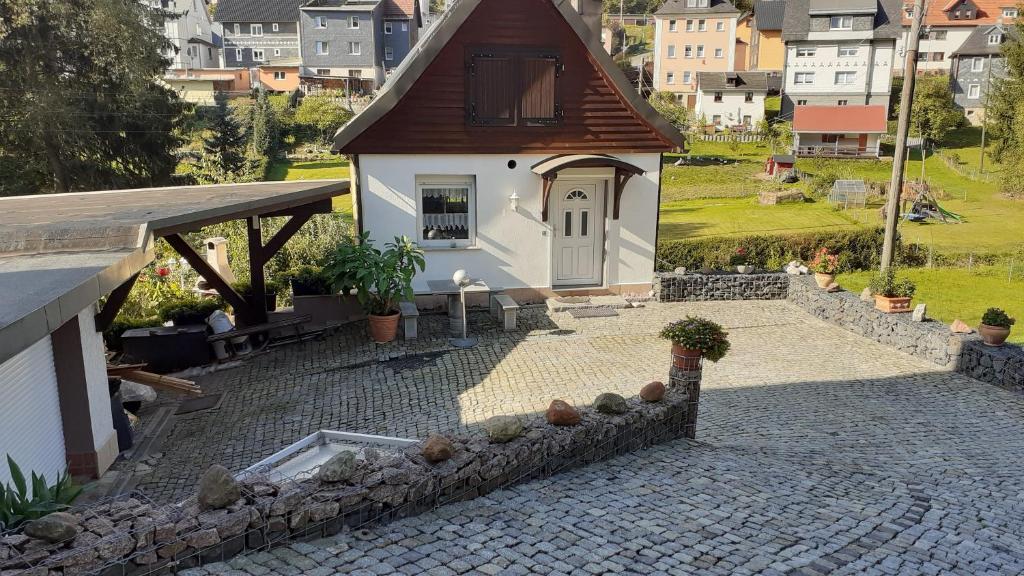 a small house with a stone walkway next to a building at Ferienwohnung Hähnlein in Steinach