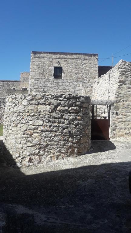 a stone wall with a door in front of a building at Πέτρινο σπίτι-Stone house in Koíta