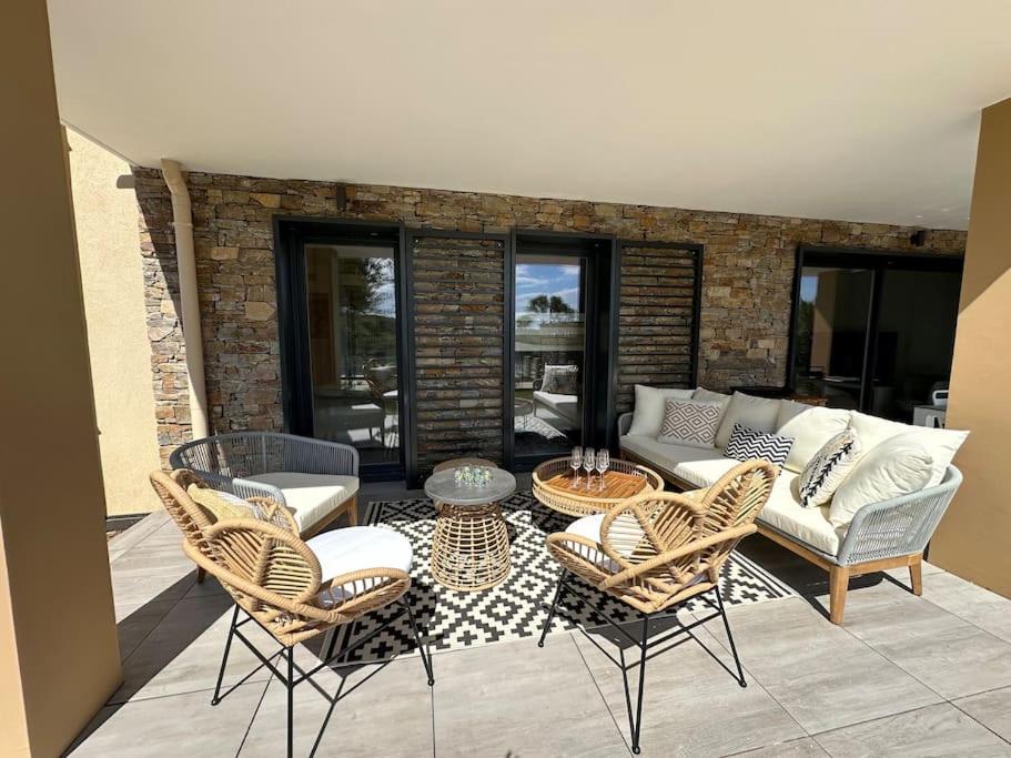 un patio avec un canapé, une table et des chaises dans l'établissement Magnifique T4 neuf de 90m2 avec jardin et piscine au cœur de Sainte Maxime, à Sainte-Maxime