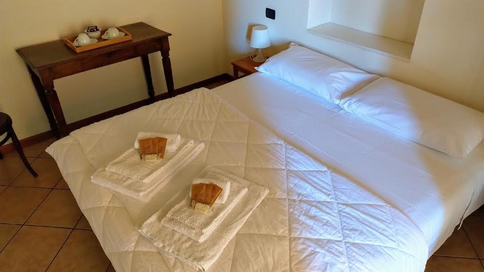 a large white bed with two towels on it at B&B Agora' in Gardone Riviera