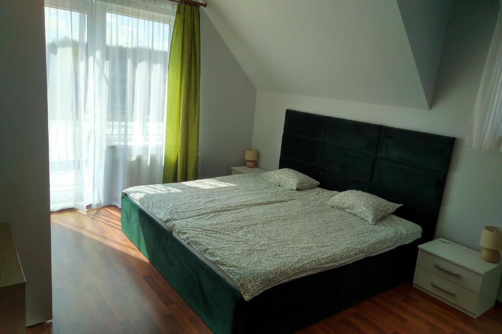 a bedroom with a bed and a large window at Wczasy u Ireny in Lubiatowo