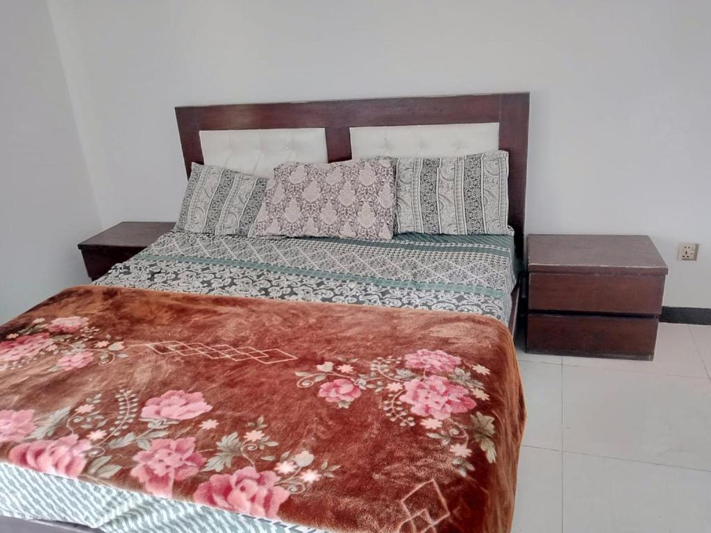a bedroom with a bed and two night stands at Murree Apartments in Murree