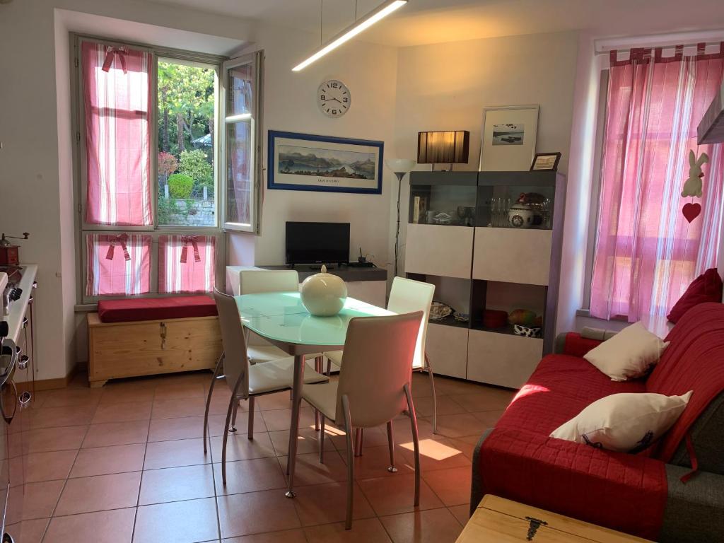 a living room with a table and a red couch at VECCHIA STAZIONE - by Satisfactual Property in Menaggio
