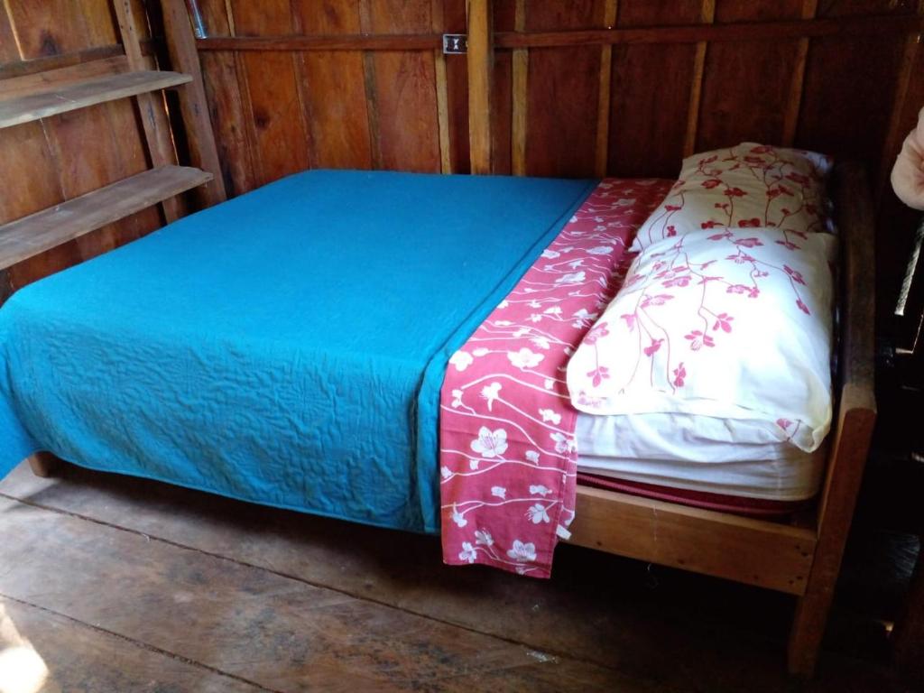 ein kleines Bett in einem Zimmer mit Holzwänden in der Unterkunft montecristo hostel in Santa Marta