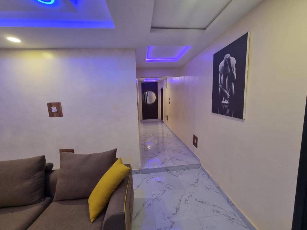 sala de estar con sofá y luz morada en Mirola Apartments en Ilorin