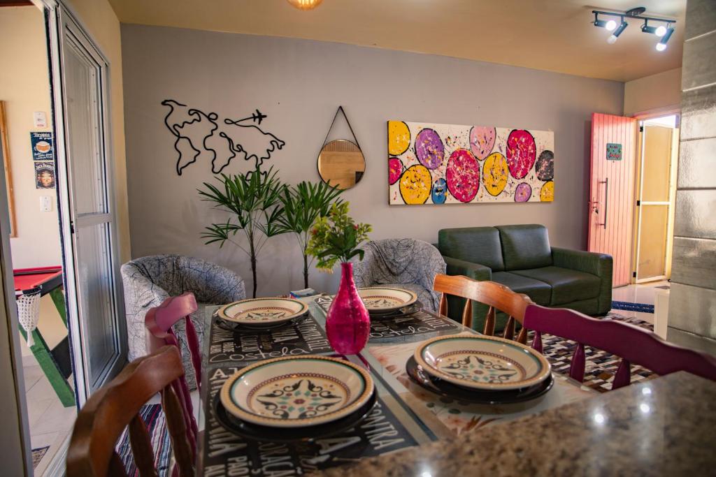 uma sala de jantar com uma mesa com pratos e cadeiras em Casa Areal, 1 Suíte, 2 quartos, piscina garagem para 2 carros em Pelotas