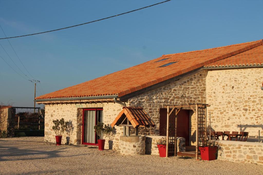 a small stone building with a red roof at Gite Le marronnier - Parthenay - 10 personnes - Gite à la campagne à 3 kms du centre-ville in Parthenay