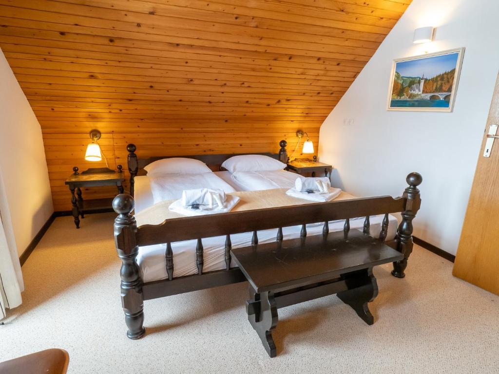 - une chambre avec un lit et un plafond en bois dans l'établissement Apartments Škantar, à Bohinj