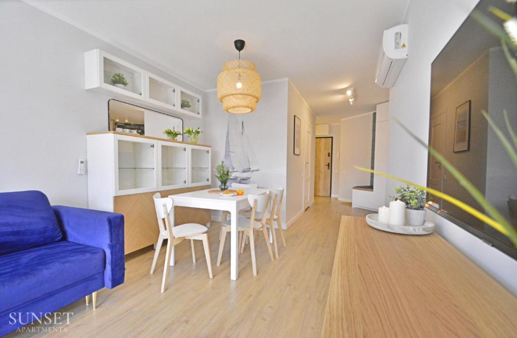 ein Wohnzimmer mit einem blauen Sofa und einem Tisch in der Unterkunft Sunset Apartments - Roosevelta - Premium - Garaż in Świnoujście