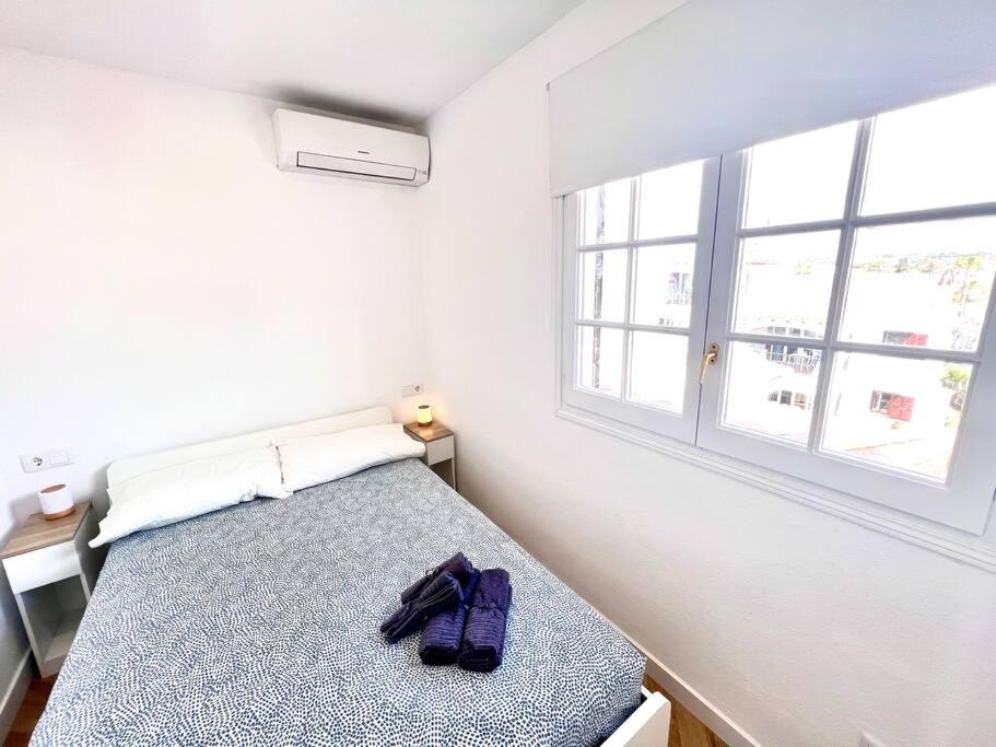 une chambre avec un lit et une fenêtre dans l'établissement Ático con vistas al mar Cala enPorter, à Cala'n Porter