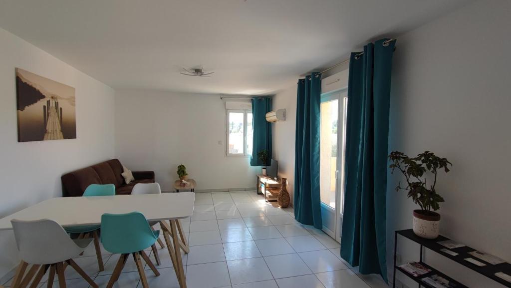 a living room with a white table and chairs at Appartement cosy in Uchaud