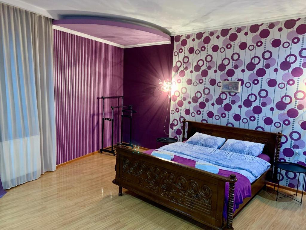 - une chambre dotée d'un lit avec un mur violet dans l'établissement Brothers, à Tbilissi