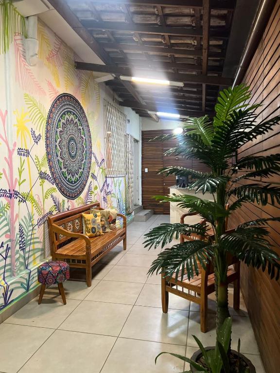 una habitación con una planta y una pared con un mural en Trem Chic en Belo Horizonte