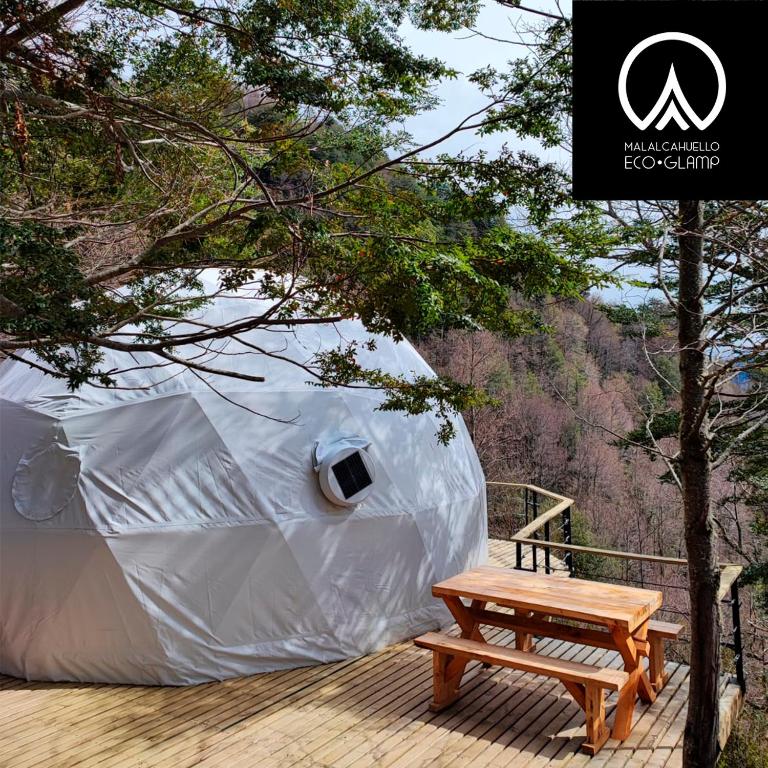 a tent with a wooden bench on a deck at Malalcahuello Eco Glamp in Malalcahuello