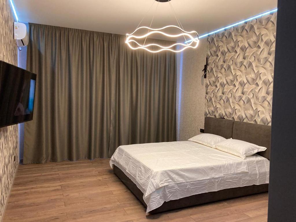 ein Schlafzimmer mit einem Bett und einem Wolkenlicht in der Unterkunft Alpamys Premium центр города in Qostanai