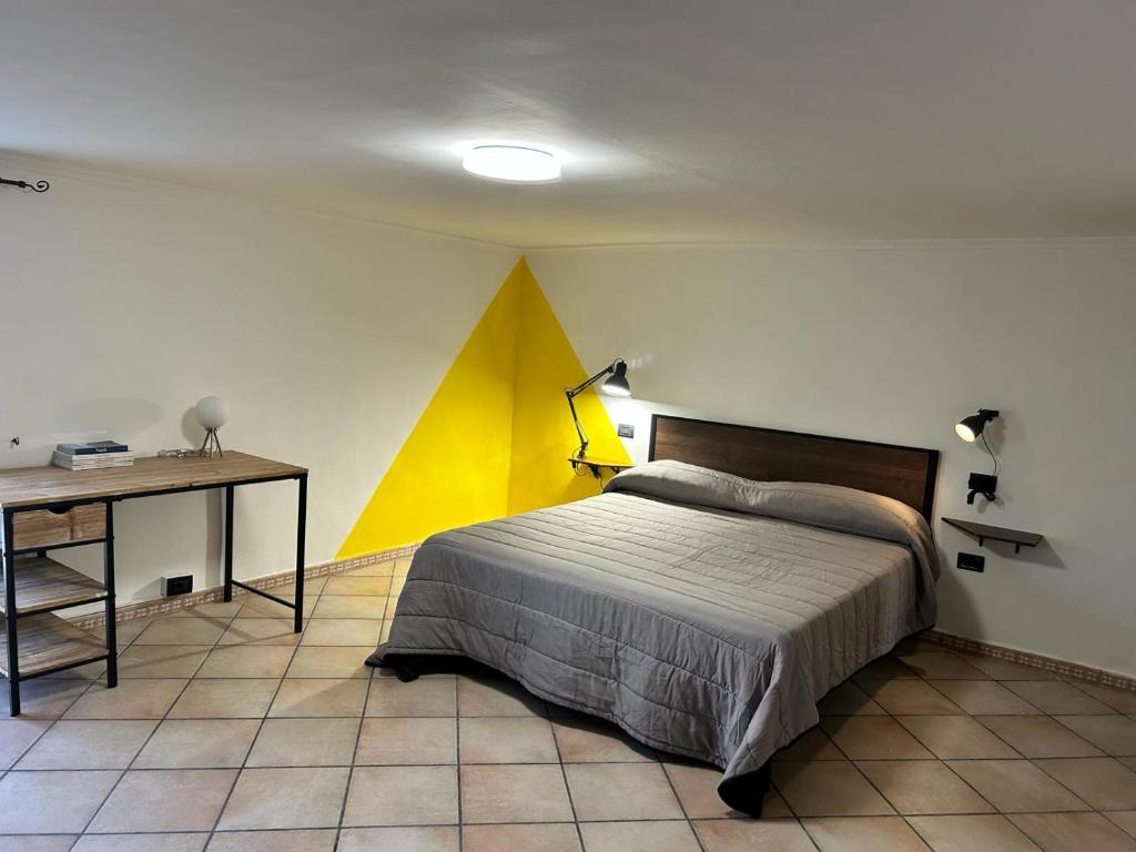 ナポリにあるB&b Next Stop Napoliのベッドルーム1室(ベッド1台、ランプ付きデスク付)