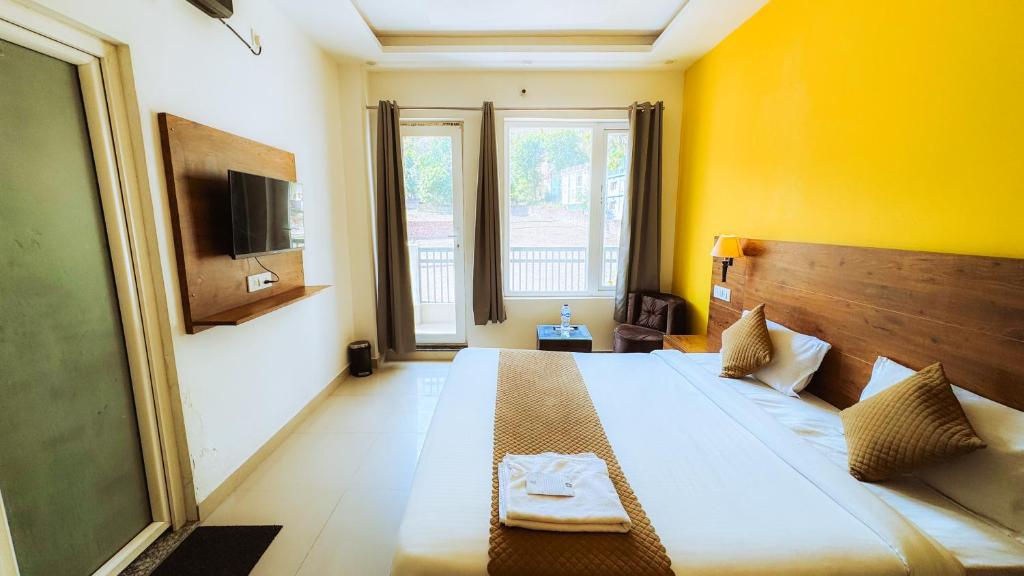 HOT - House Of Travellers في ريشيكيش: غرفة نوم بسرير كبير وجدار اصفر