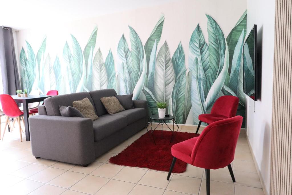 - un salon avec un canapé et des fauteuils rouges dans l'établissement Plaza Vienne 01, à Montévrain