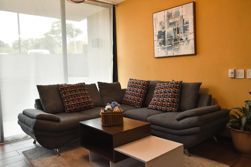 uma sala de estar com um sofá e uma mesa em Infinity Pool Apartment em San Salvador