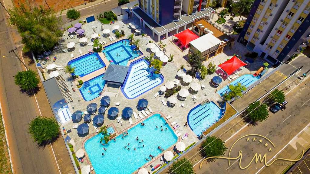 an overhead view of two swimming pools with umbrellas and chairs at Eldorado Thermas Park RM Hospedagem in Caldas Novas