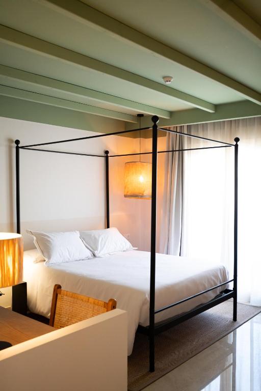 a bedroom with a large bed with a black frame at Rooms by JovA in El Campello