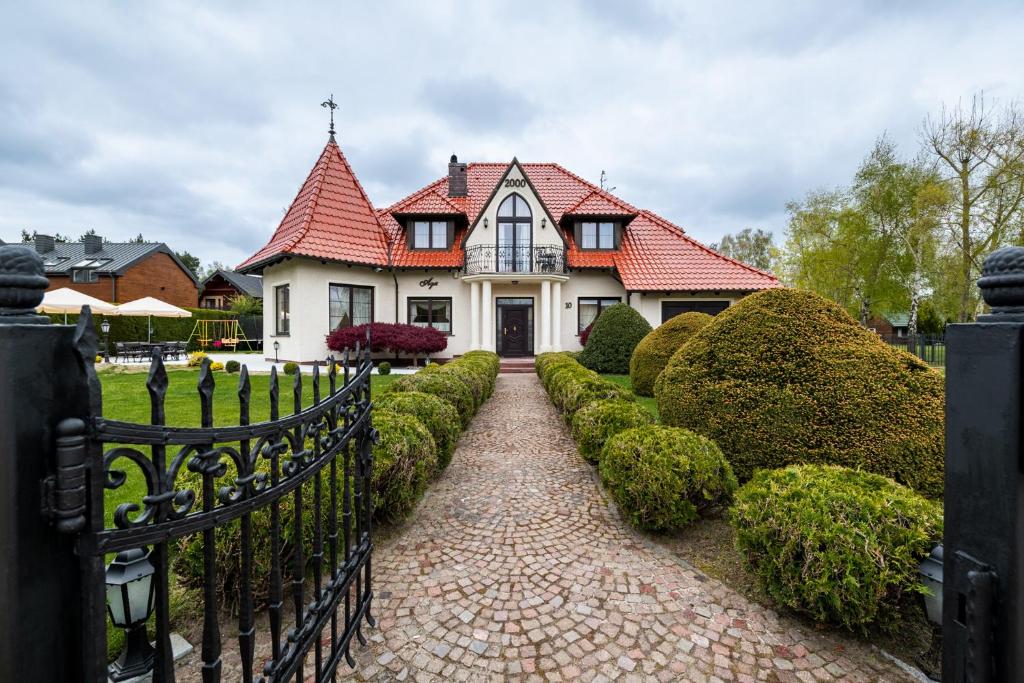 a white house with a red roof and a driveway at Willa Aga in Dębki