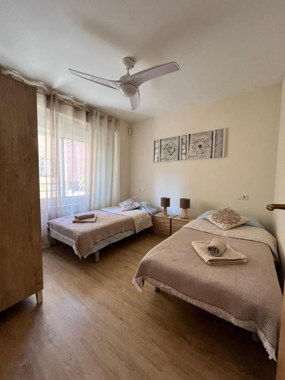 - une chambre avec 2 lits et un ventilateur de plafond dans l'établissement SANTA BARBARA APARTAMENTO, à Alicante