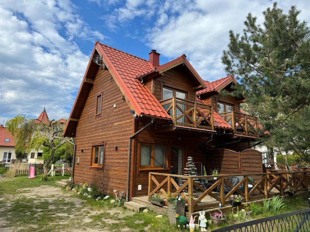 a wooden house with a red roof at Domki całoroczne KATRINA in Krynica Morska