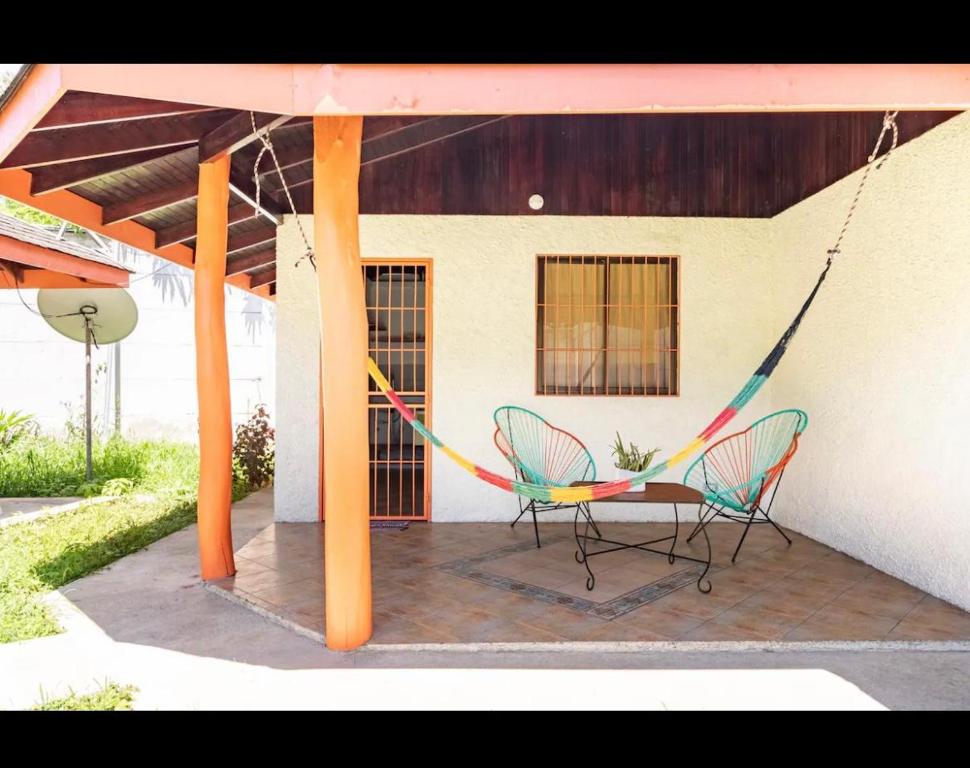 2 sillas y una hamaca en el patio en bungalow cactus frente ala playa, en Cahuita