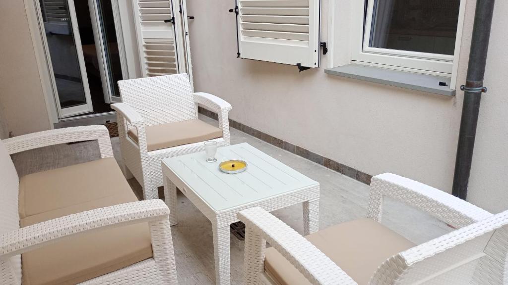 una pequeña mesa blanca y sillas en el balcón en LOFT CON CORTILE, en Forlì