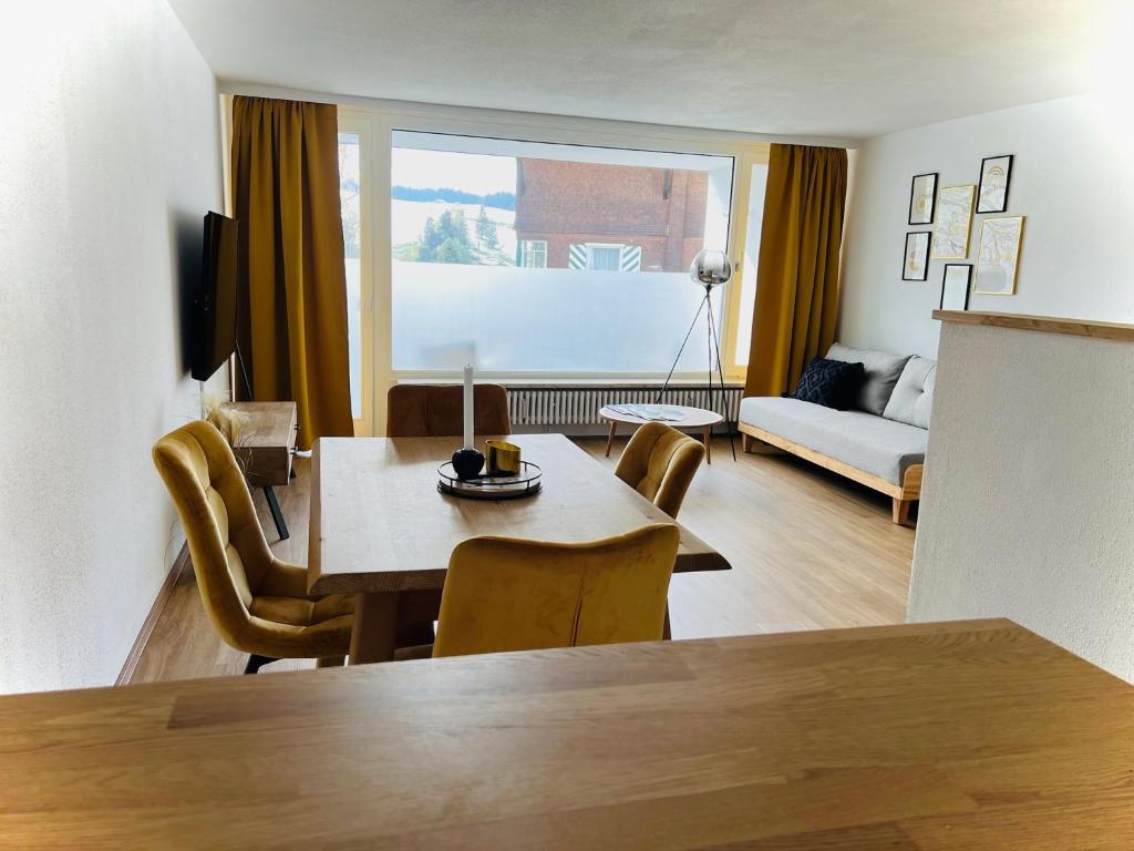 uma sala de estar com uma mesa e cadeiras e um sofá em Ferienwohnung Sonneck em Oberstaufen