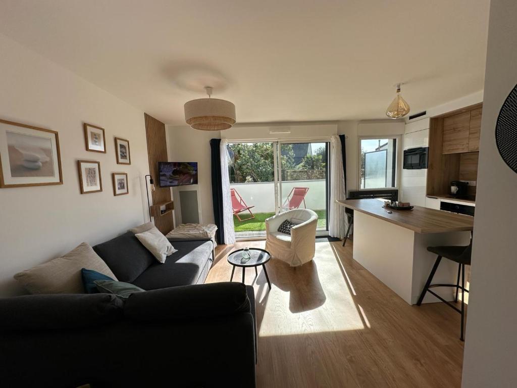 een woonkamer met een bank en een keuken bij Arradon Golfe du Morbihan Appartement 2 Pièces plain-pied Terrasse in Arradon