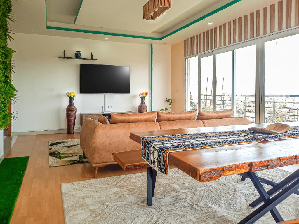 a living room with a couch and a flat screen tv at Appartement African Chic in Dakar