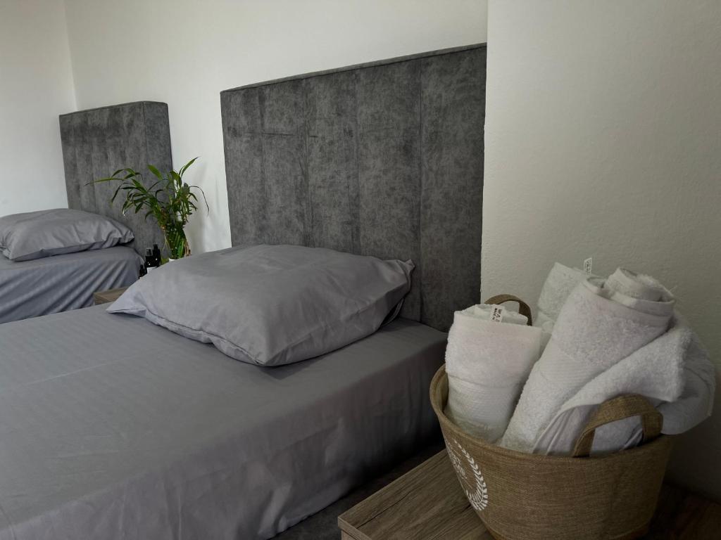 um quarto com uma cama e uma cesta de toalhas em Hostel by Fenix Tirana em Tirana