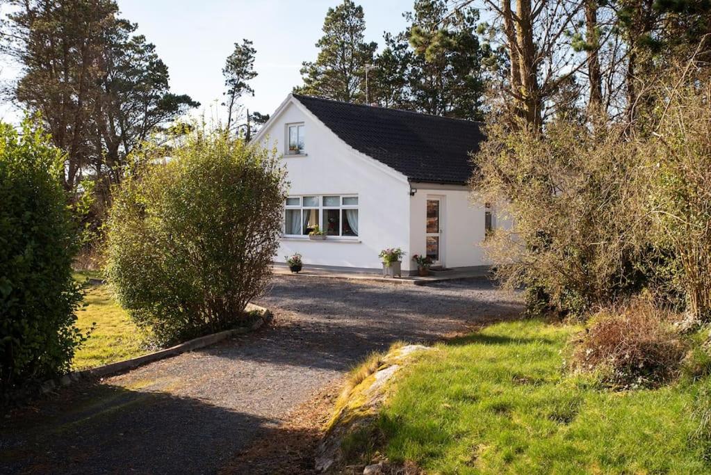 Casa blanca con entrada y árboles en Carna Chalet, en Galway