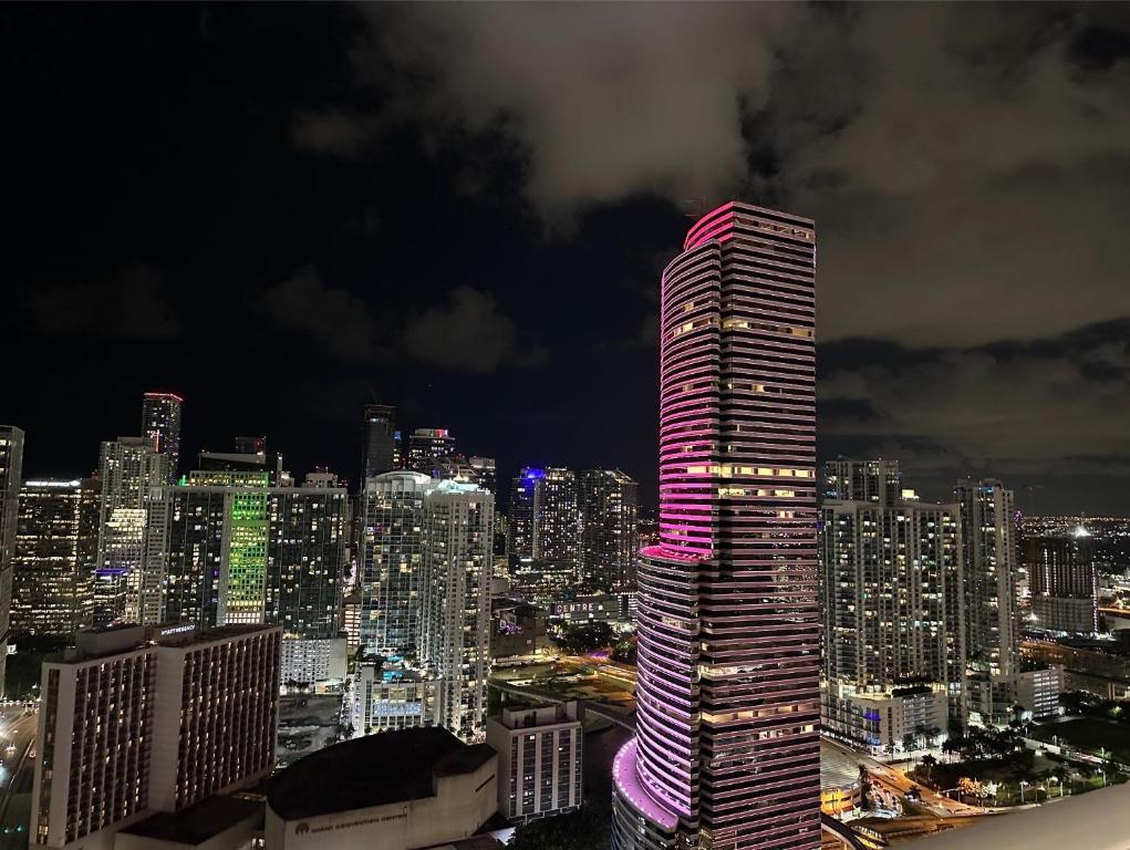 um edifício alto com luzes cor-de-rosa numa cidade em Luxury Loft Miami Downtown Brickell em Miami