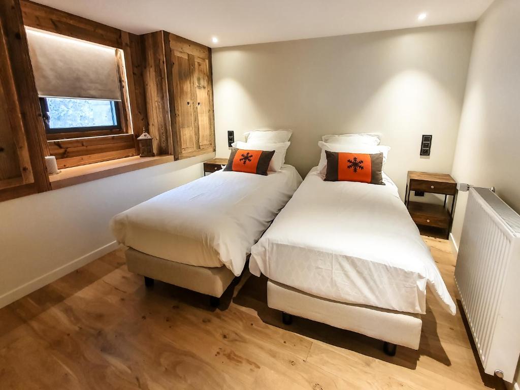 a bedroom with two beds and a window at Les Fermes de Cal Panche : Le Cabanat in Les Angles