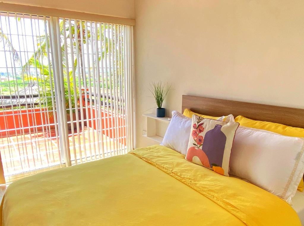 a bedroom with a bed with a large window at Palma Sol in Pampatar
